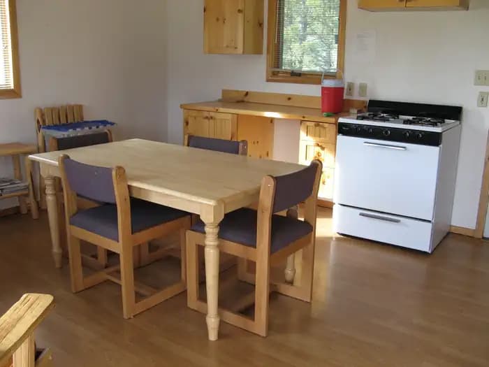 A small wooden kitchen table and counters in a cabin