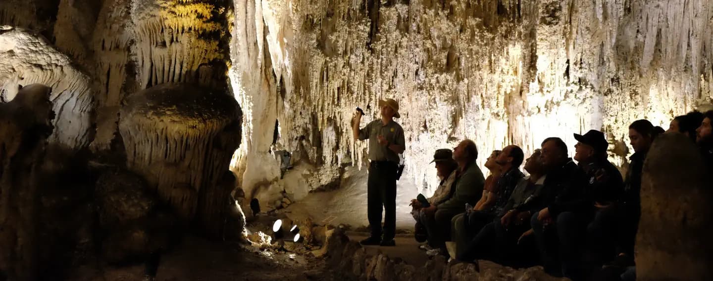 Visitors and Park Ranger in foreground with cave formations in the background