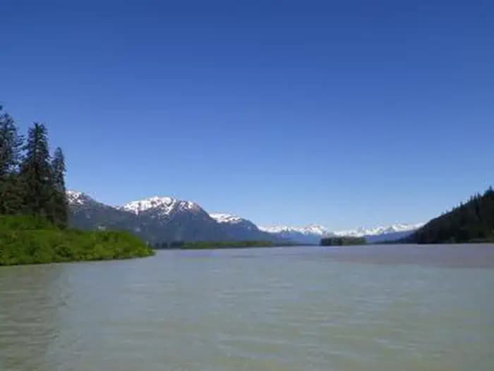 Shakes Slough 1 Cabin view featuring snowcapped mountains and water in foreground