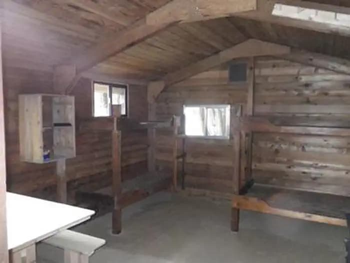 Harding River Cabin wood interior with wood bunkbeds and table