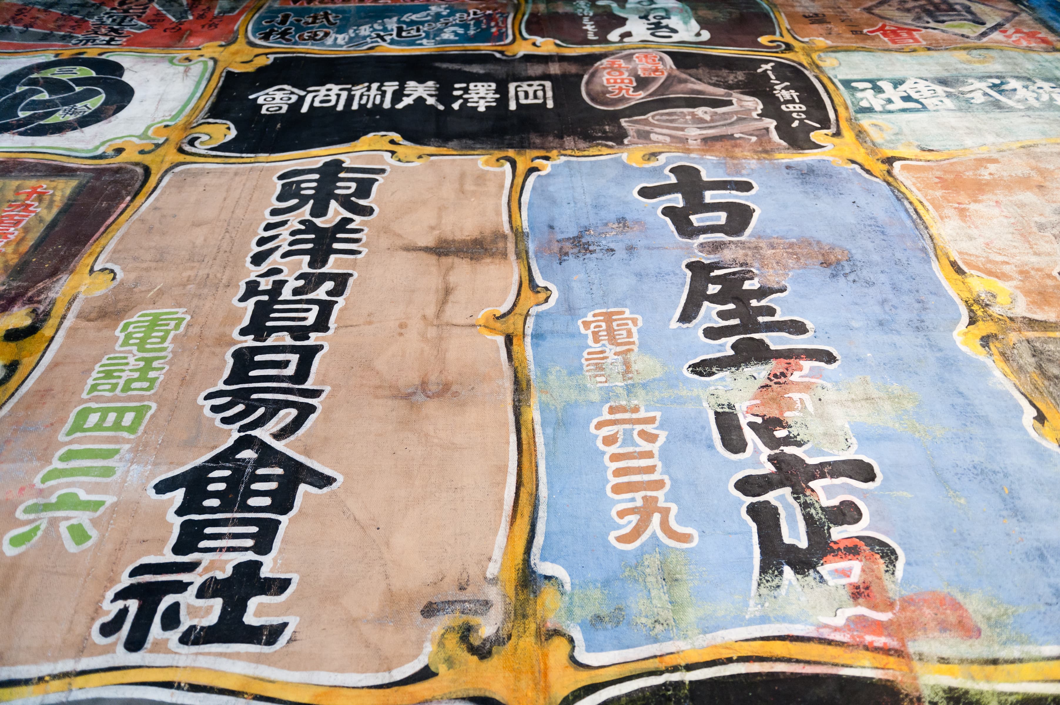 Detail of advertisements from the Nippon Kan Theatre curtain that hangs in the museum