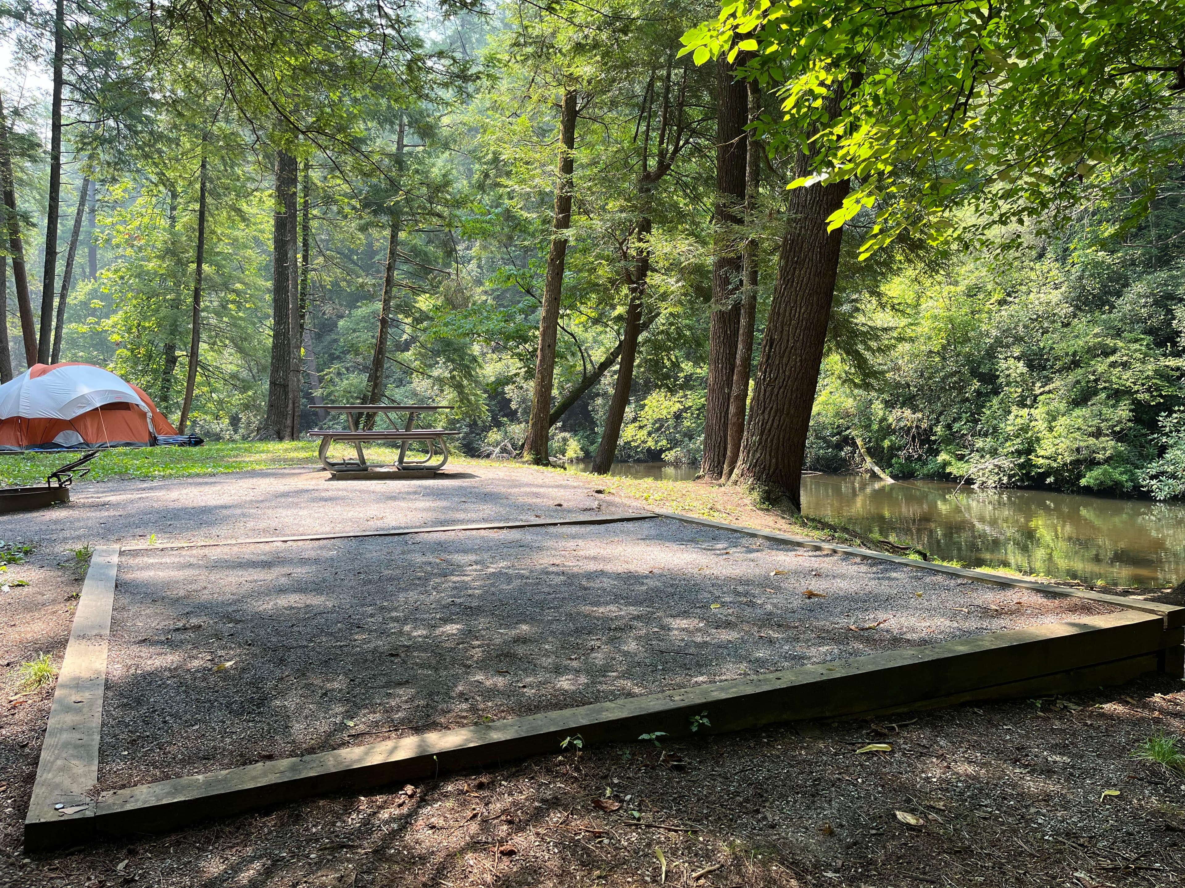 Each site offers a gravel tent pad, a grill, and a picnic table. Nearby sites are typically visible.